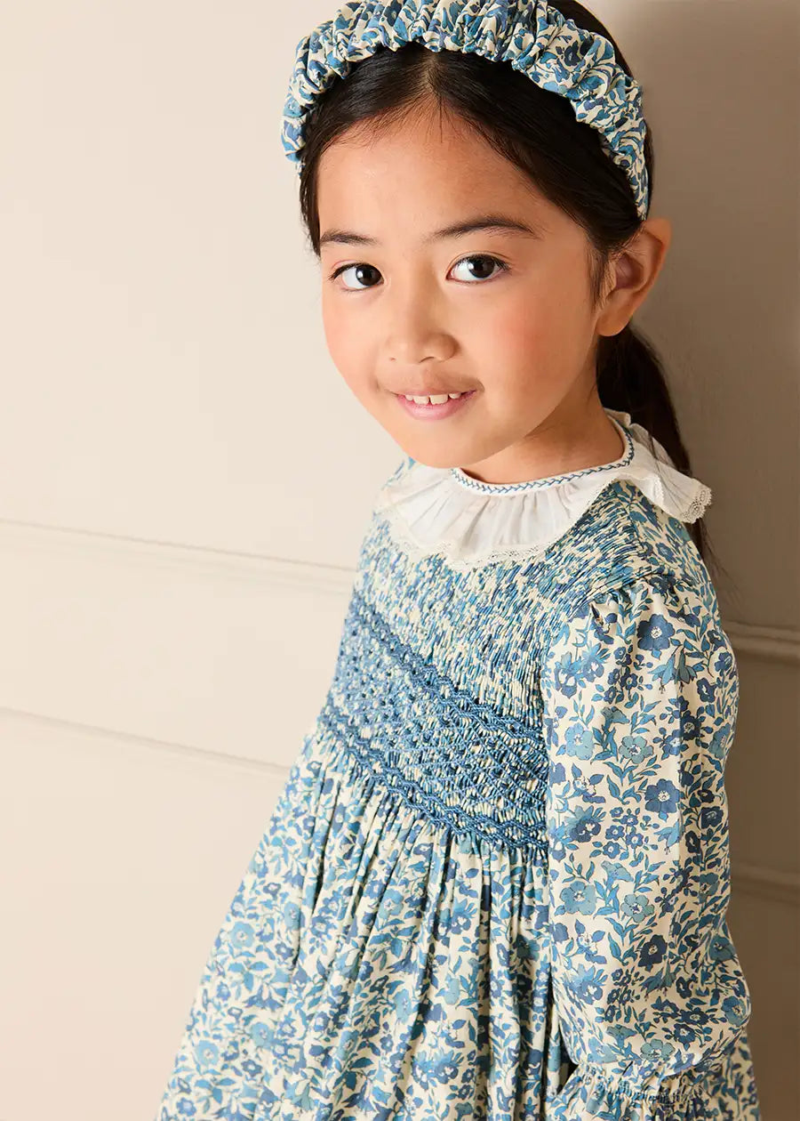Daphne Floral Hand Smocked Frill Collar Long Sleeve Dress in Blue (18mths-10yrs) Dresses from Pepa London