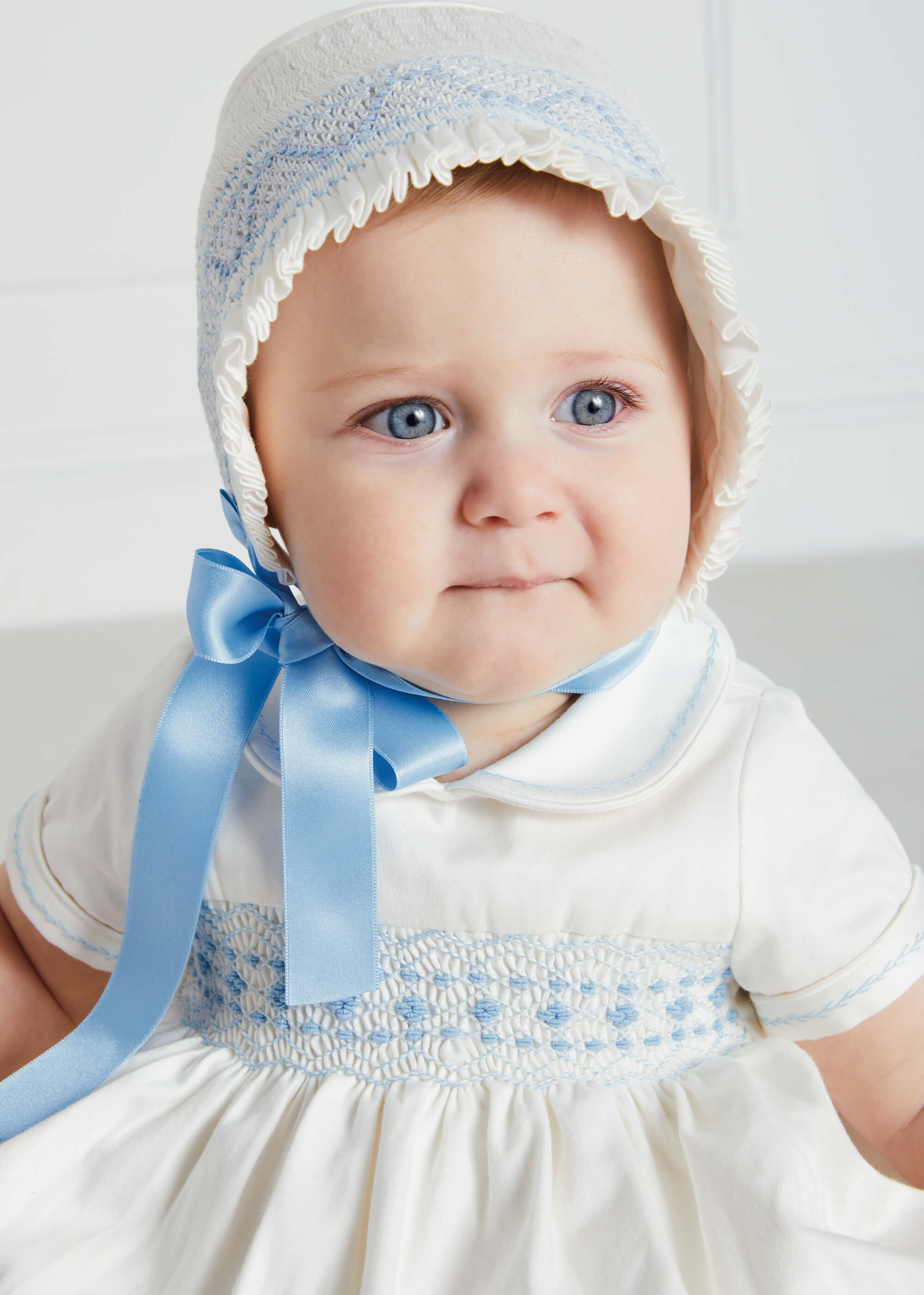 Off White and Blue Hand Smocked Baby Bonnet Knitted Accessories  from Pepa London